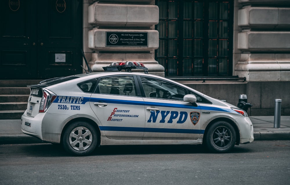 white Toyota Prius NYPD Cruiser parked near concrete building during daytime