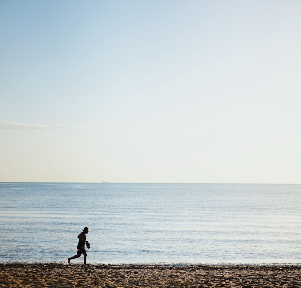 person running on shore during daytime