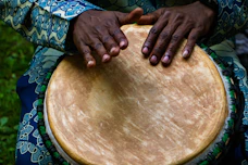 person tapping on traditional drum instrument