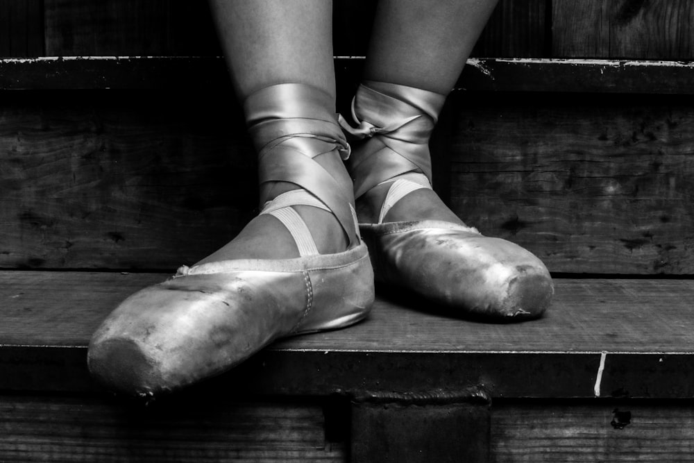 grayscale photograpghy of person wearing pointe shoes