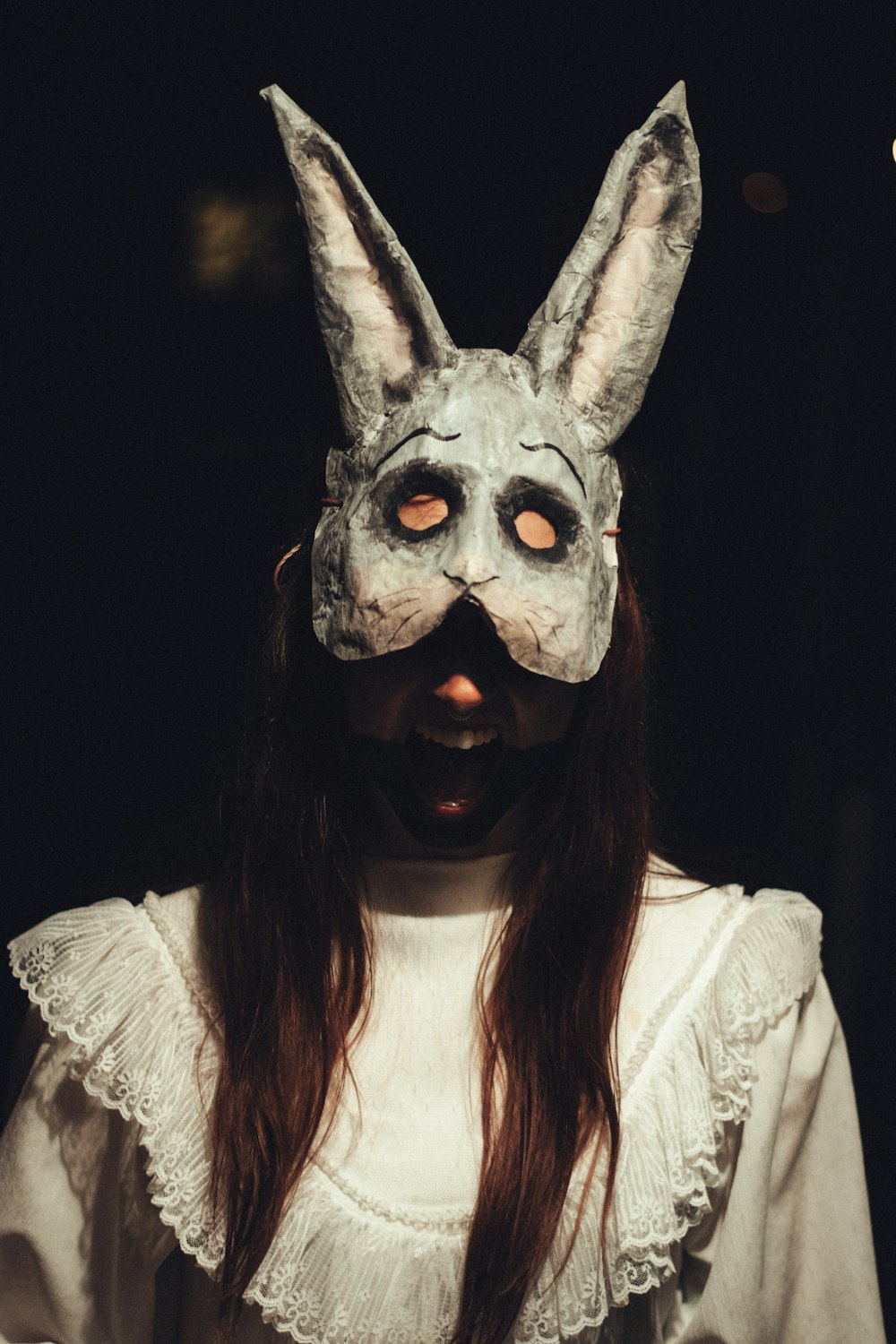 Femme portant un masque de lapin gris