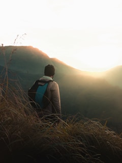 man standing on top of mountain during daytime