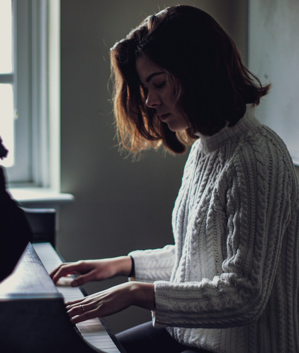 woman playing piano inside house