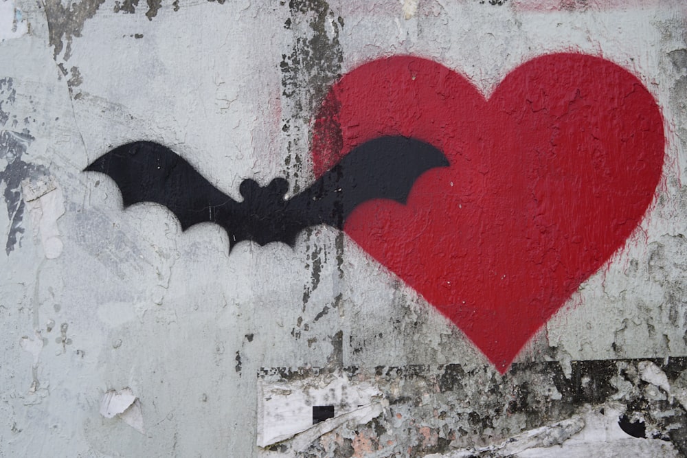 a red heart with a bat painted on it