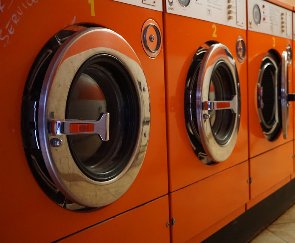 three red front-load clothes dryers