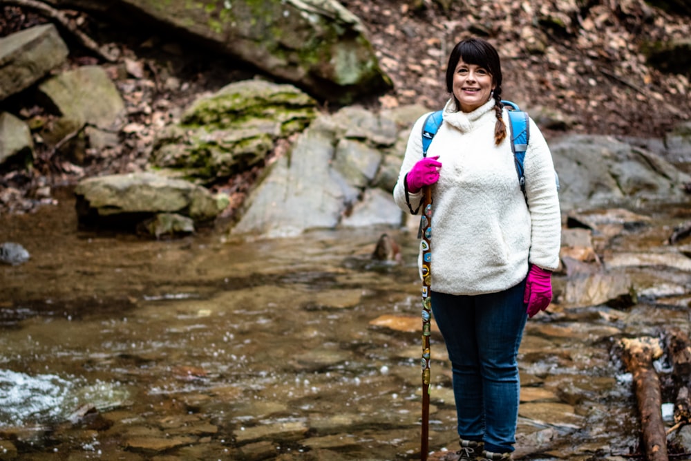 smiling woman beside water stream