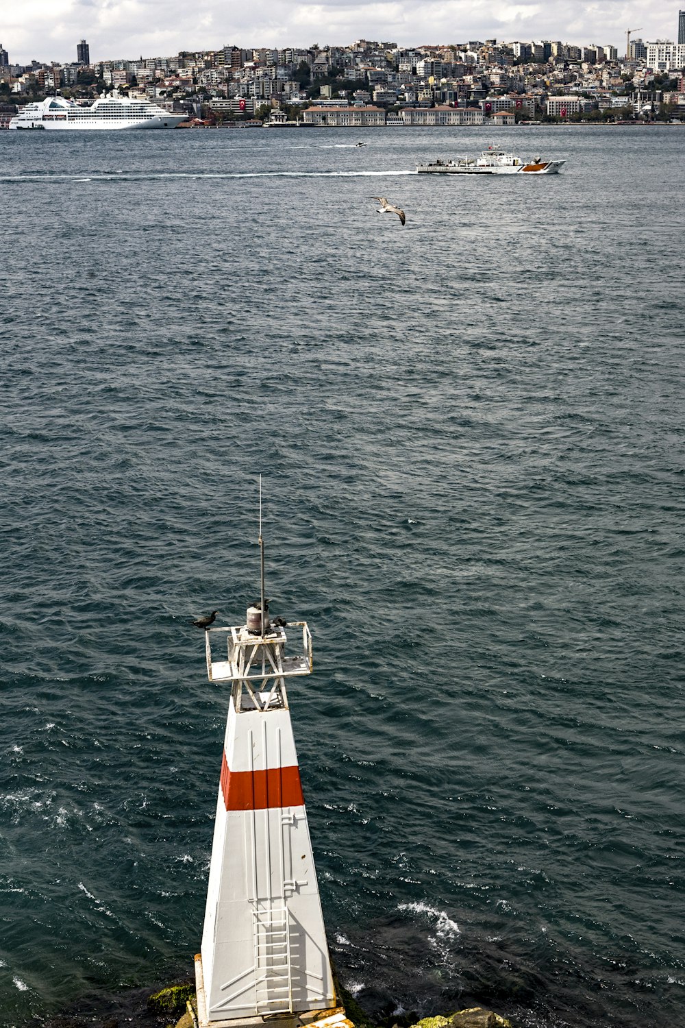 Torre de vigilancia blanca y roja junto al cuerpo de agua