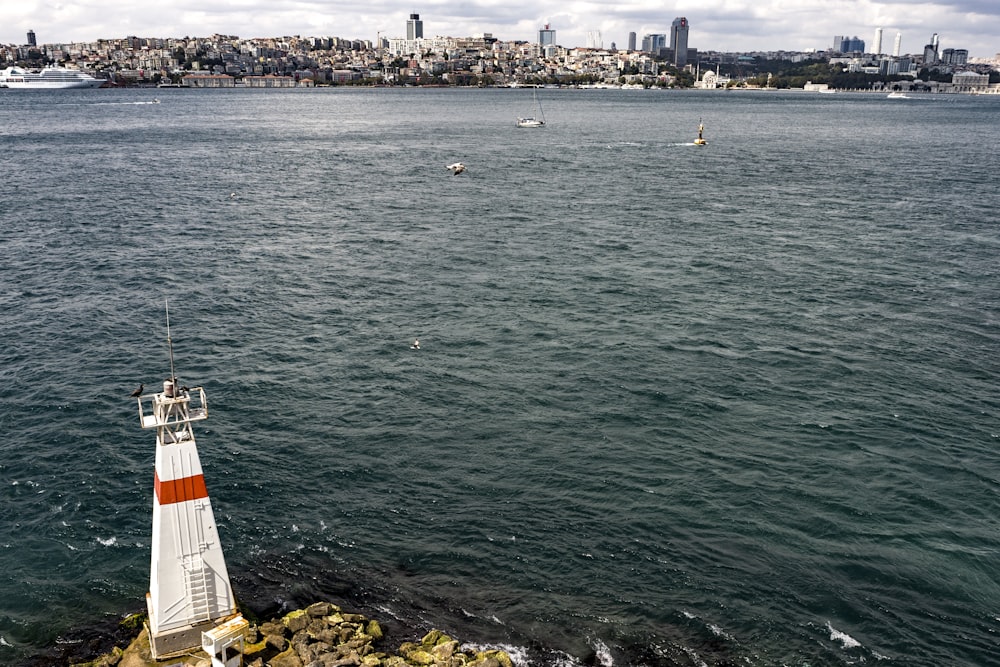 white and red lighthouse on cliff during daytime