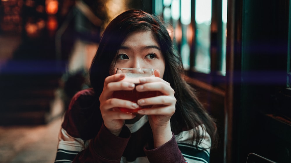 woman holding beverage filled cup