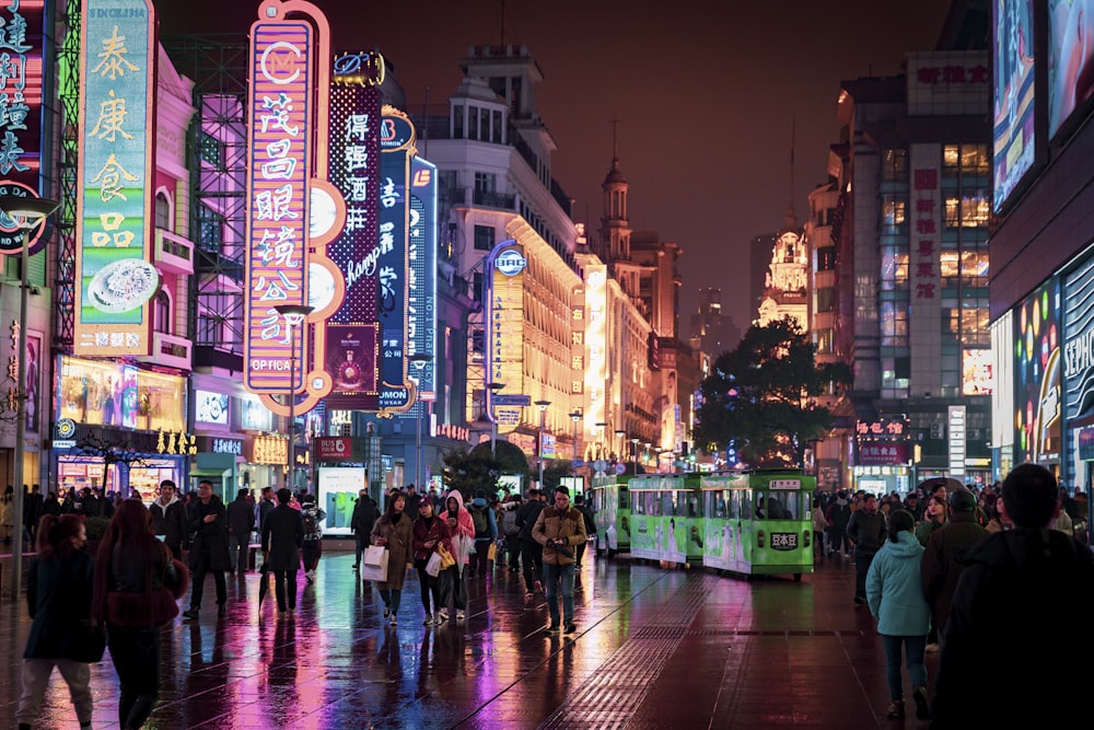 people walking and standing at the streets of the city during night