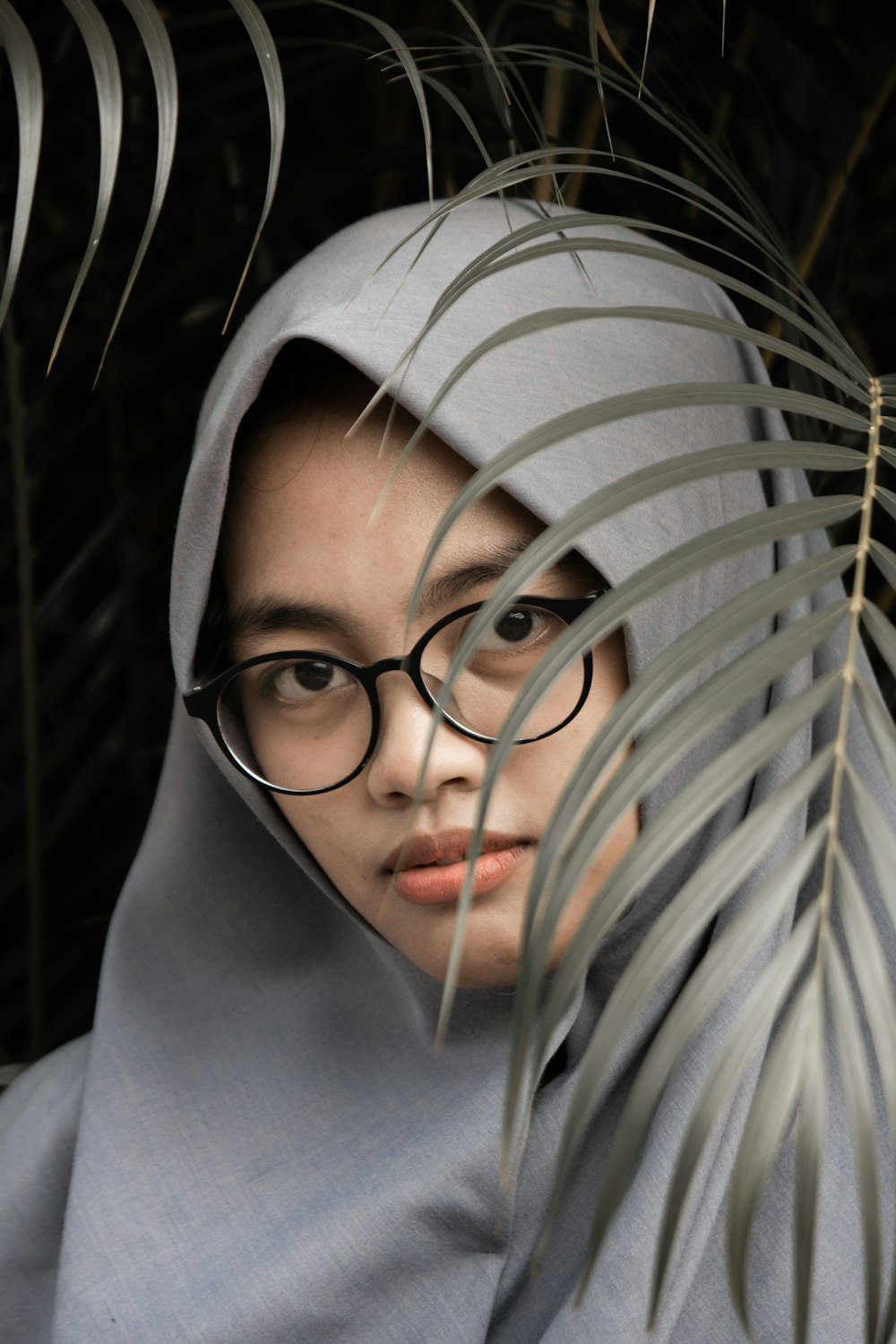 mulher usando óculos pretos e lenço cinza hijab
