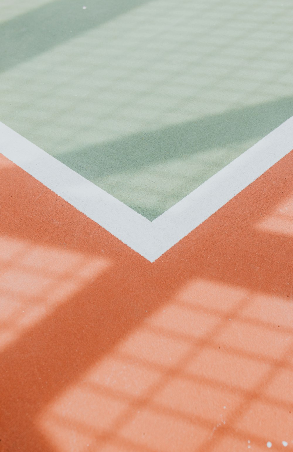 the shadow of a tennis player on a tennis court