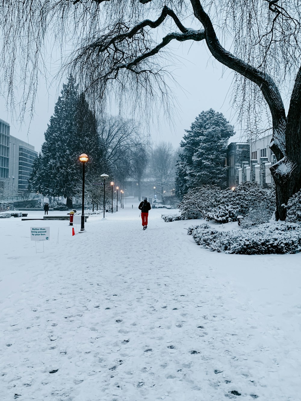 man walking on snow covered road