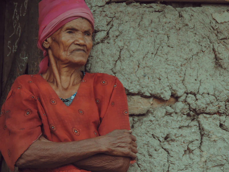 Sugar Mommy colombiana con top de cuello en V, brazos cruzados, apoyada en la pared
