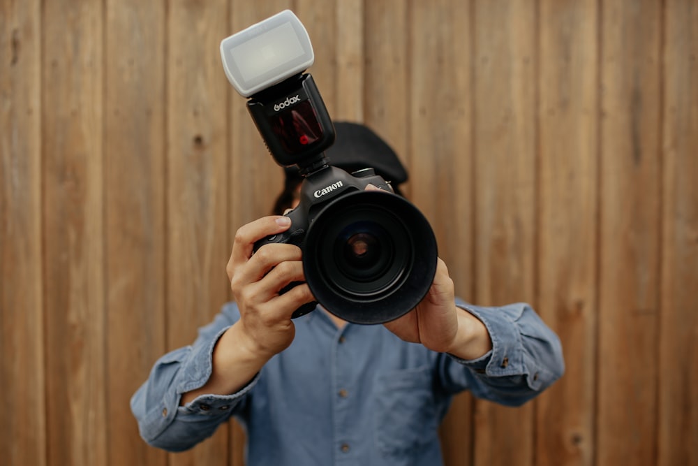 person holding black Canon camera