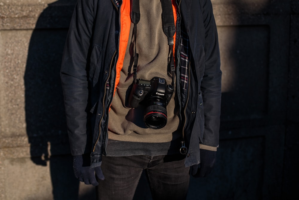 black DSLR camera on person's neck