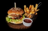 hamburger beside fries and ketchup- Rasa Veda Hotel Shikohabad