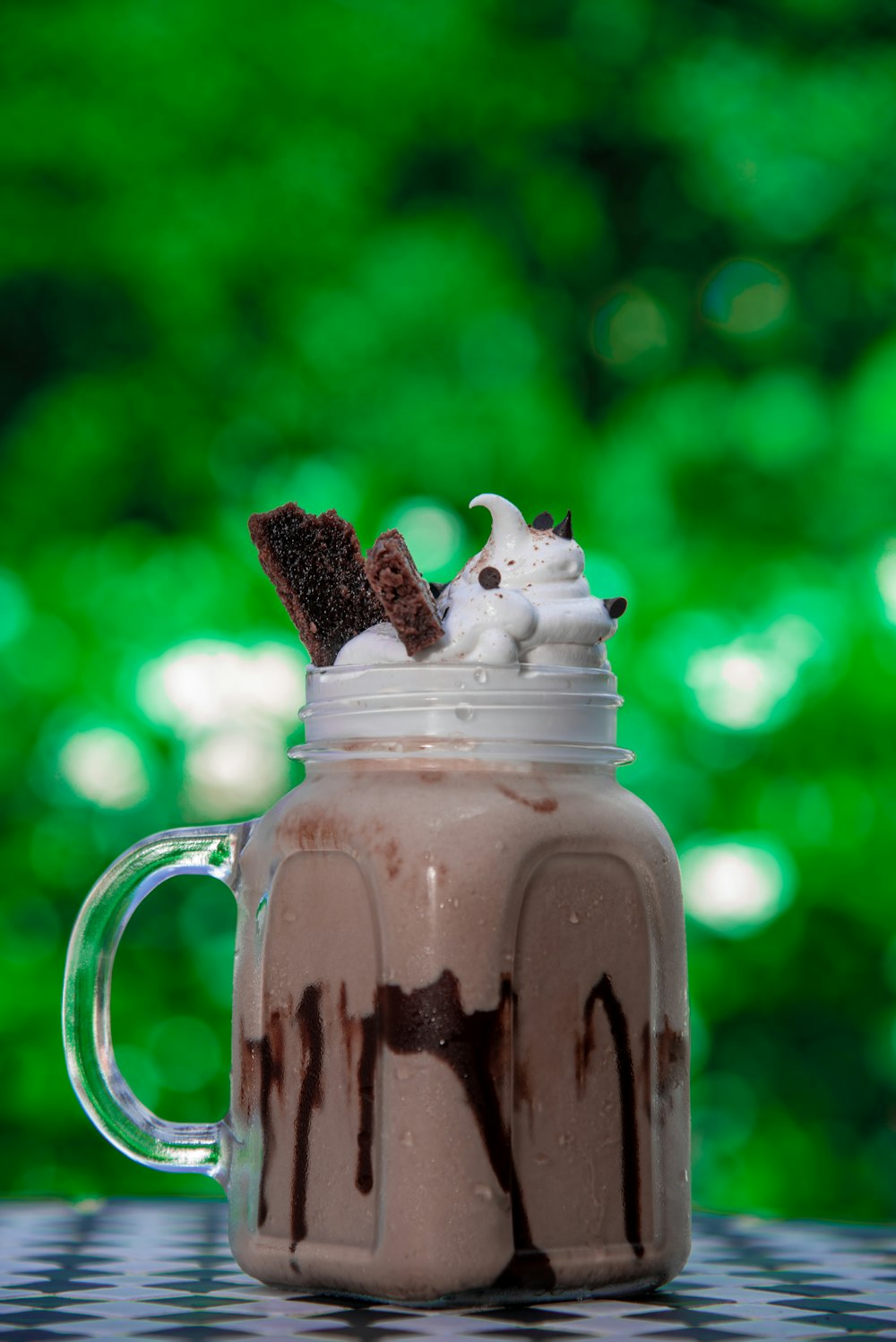 a cup of chocolate milkshake with whipped cream and chocolate on top