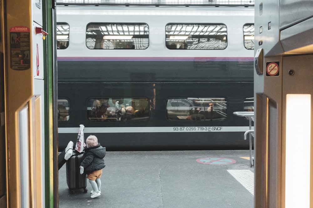 a woman standing next to a train at a train station