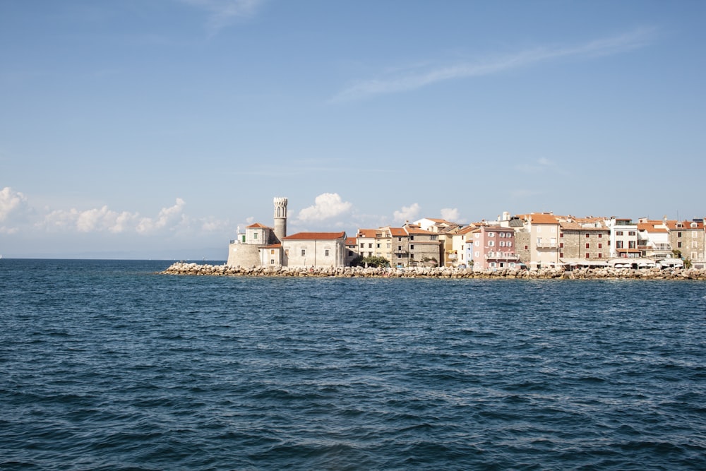 white high rise building beside body of water