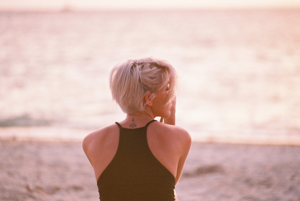 Frau trägt schwarzes Neckholder-Oberteil mit Blick auf den Strand