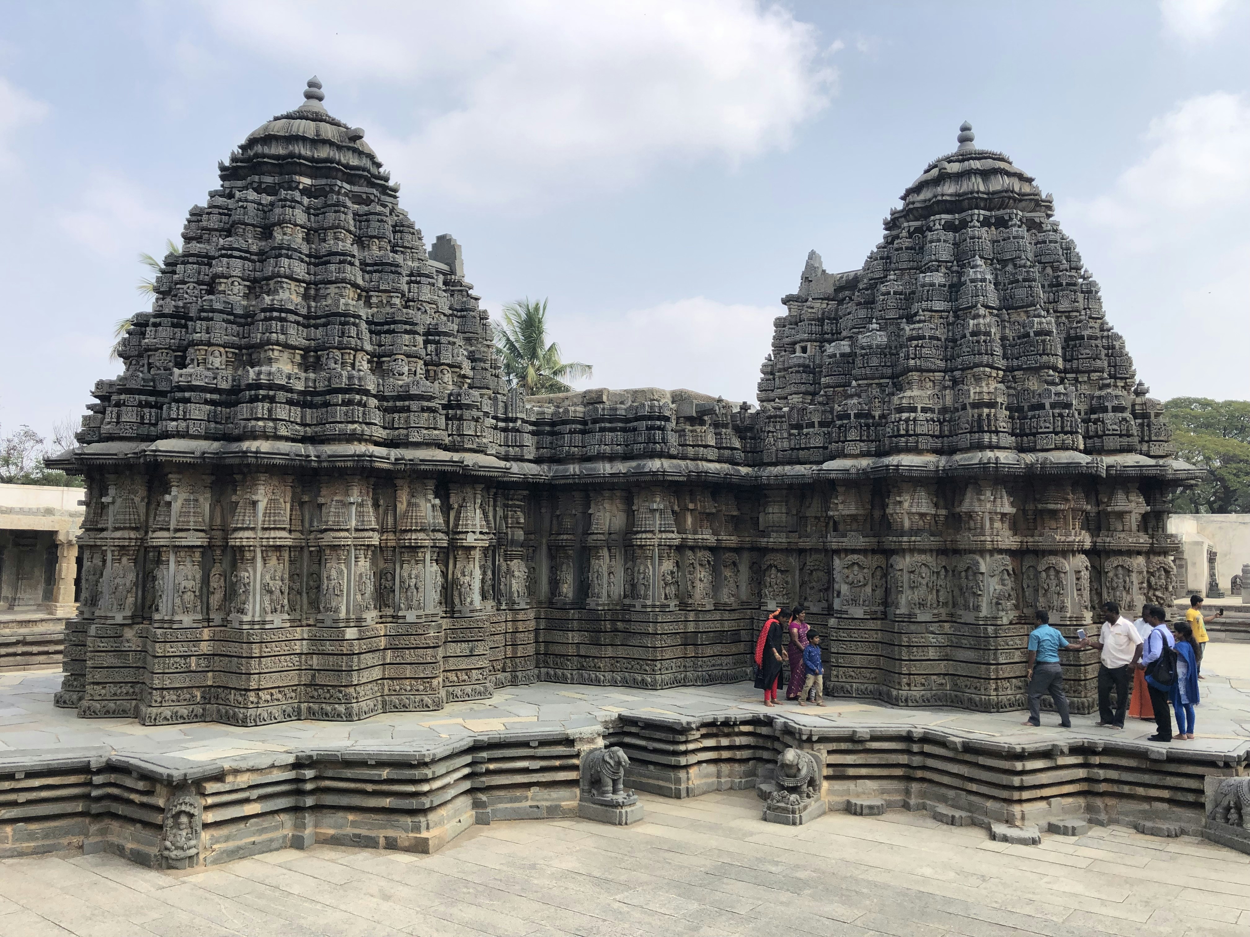 people standing beside concrete building under white clouds