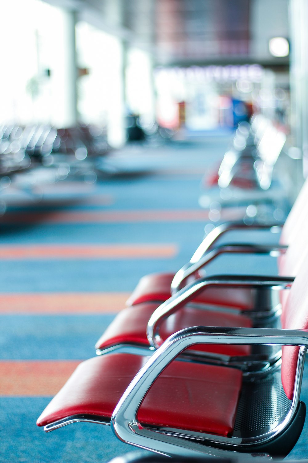 selective focus photography of red and silver gang chair