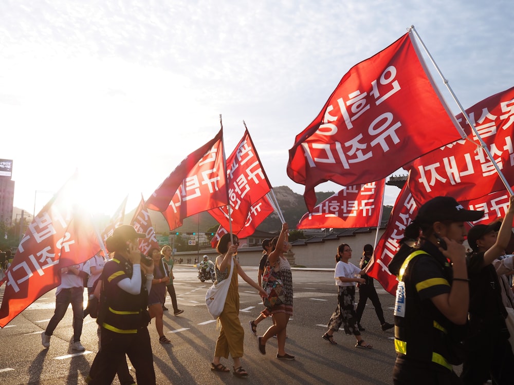 people walking and holding banner on road during daytime