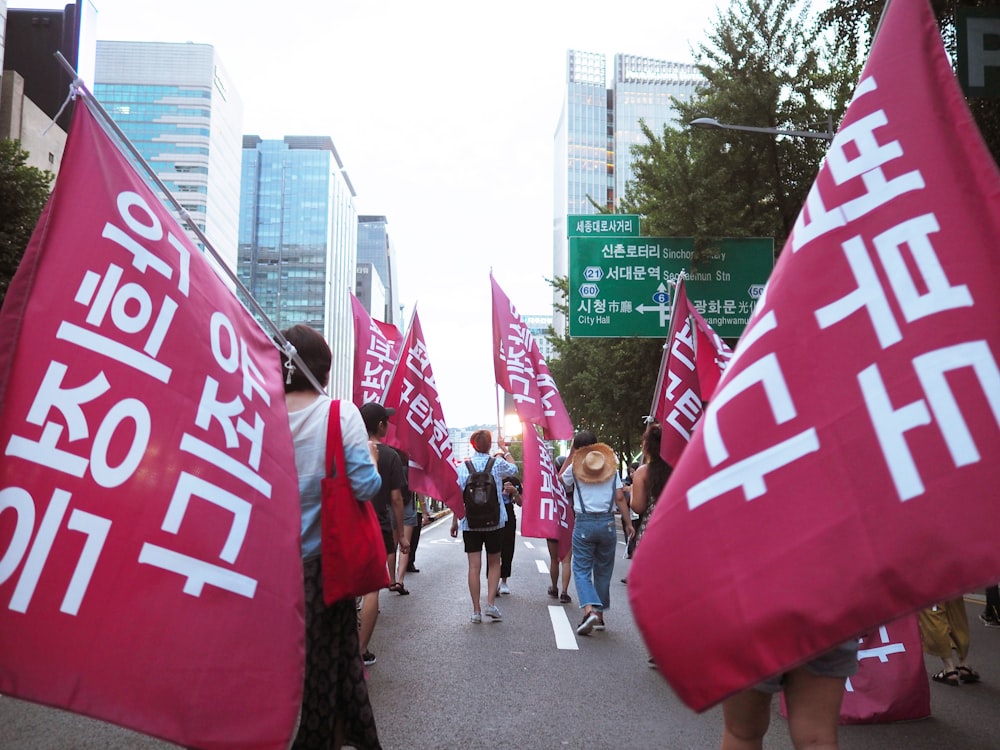 people on road with banners during daytime