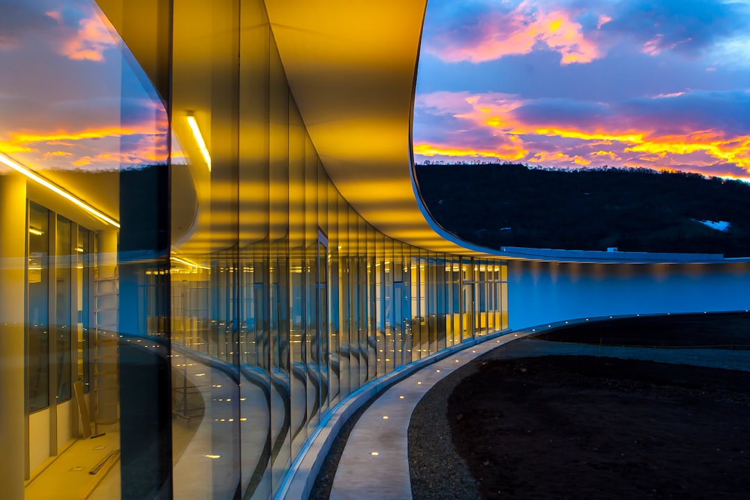clear glass wall building under blue sky with clouds,