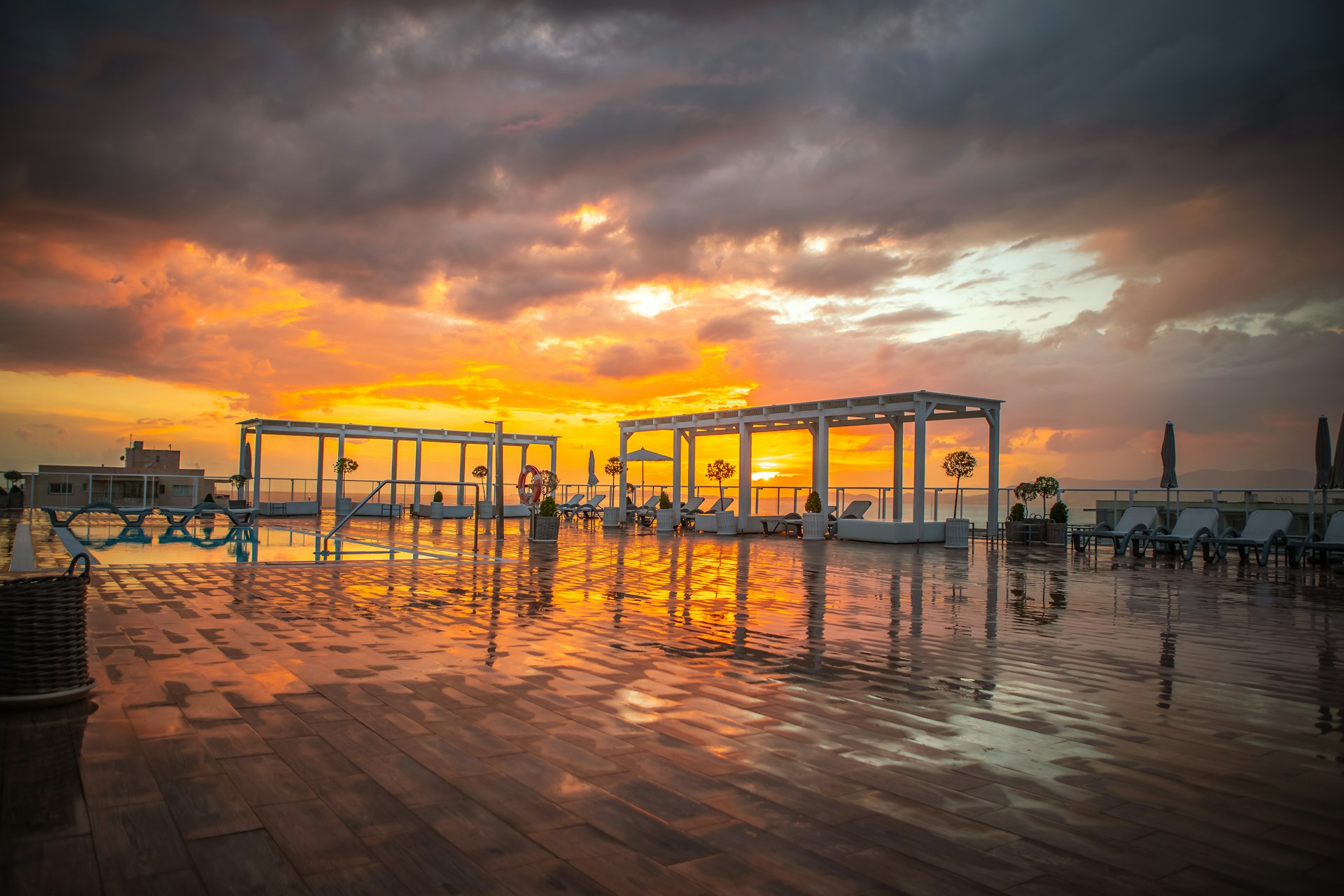 Guests enjoying a quiet moment at the rooftop lounge, with deep ocean blue decor and twinkling city lights in the background.