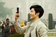 A joyful traveler capturing a selfie in front of a famous landmark during a guided tour.