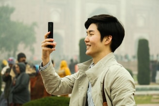 A joyful traveler capturing a selfie in front of a famous landmark during a guided tour.