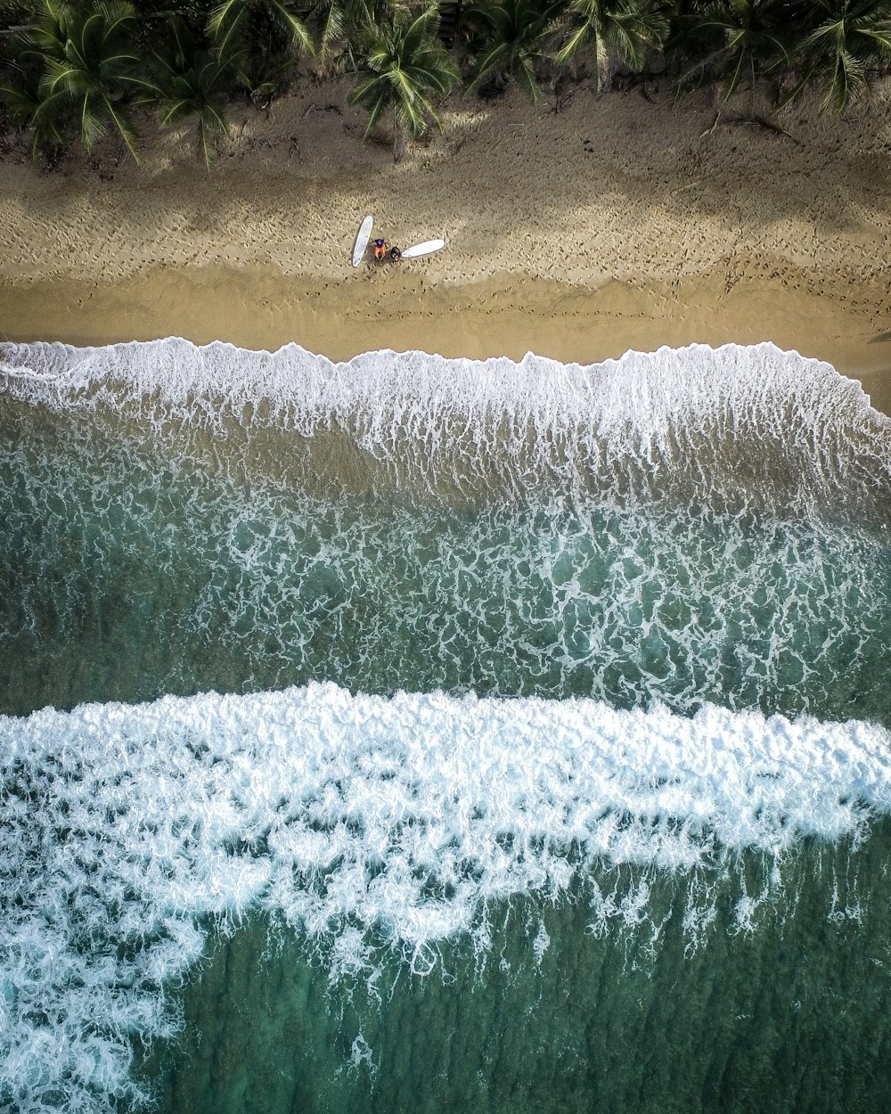 two surfboards and one person at the shore during day