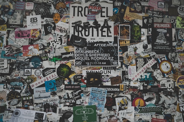 A vibrant collage of printed materials including banners, stickers, and embroidery.
