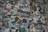 A chaotic collage of various stickers, posters, and flyers layered on a surface. The overlapping images and texts create a dense and vibrant atmosphere, featuring a mix of artistic designs, advertisements, and messages in multiple languages. Some elements include band names, events, artistic logos, and social tags.