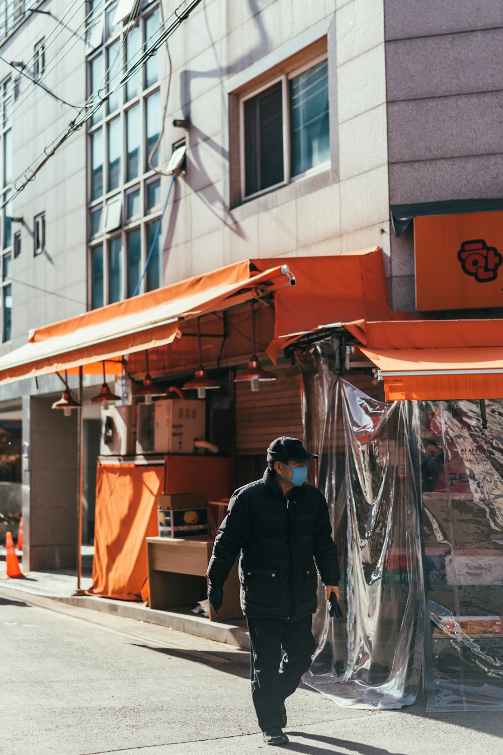 man walking on street beside store during daytime