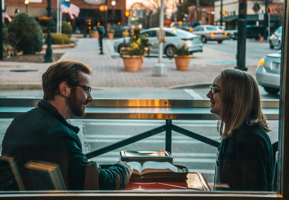 A couple sitting together outside, talking naturally