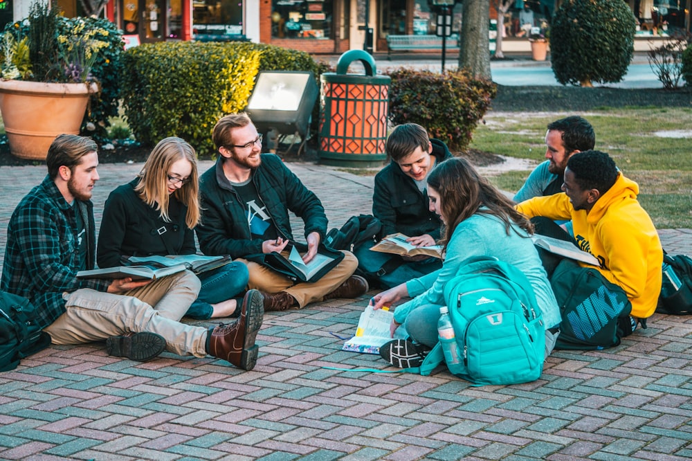 group of people sitting on pave blocks