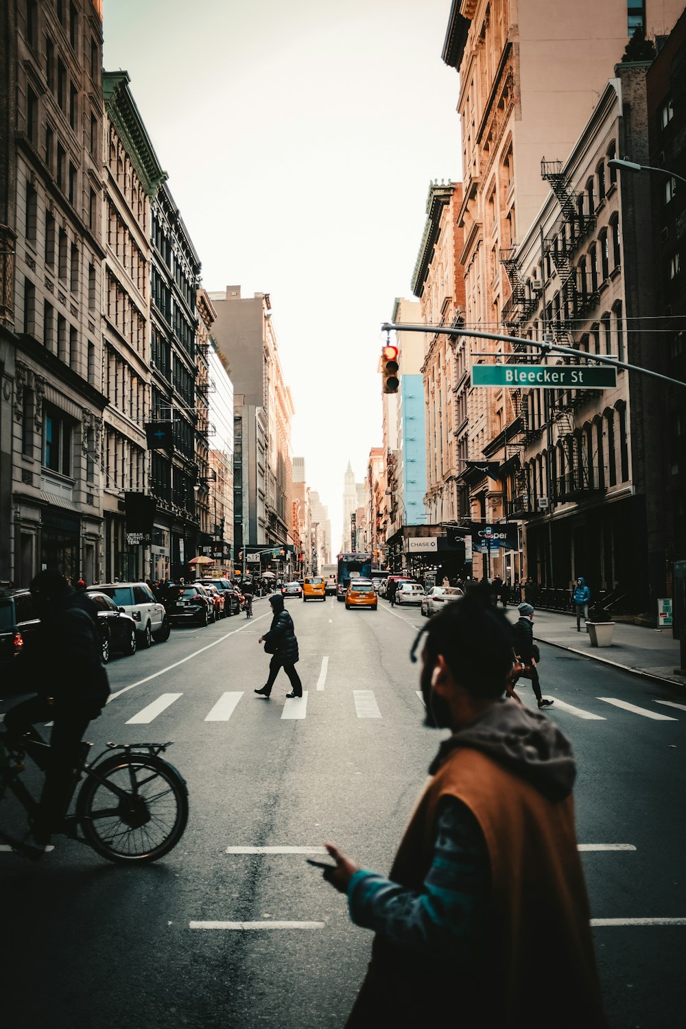 people crossing street between buildings