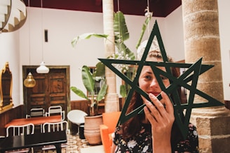 woman holding two star decors in front of her face