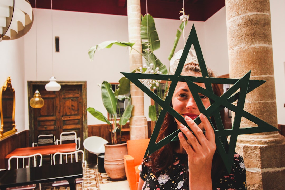 woman holding two star decors in front of her face