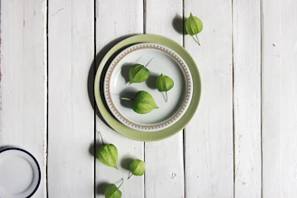 A rustic stoneware serving platter in mustard and coral hues set on a linen cloth with seasonal vegetables.