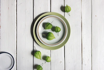 A rustic stoneware serving platter in mustard and coral hues set on a linen cloth with seasonal vegetables.