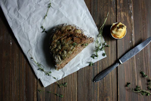 Close-up of a rustic artisanal bread and fresh farm produce arranged beautifully on parchment paper