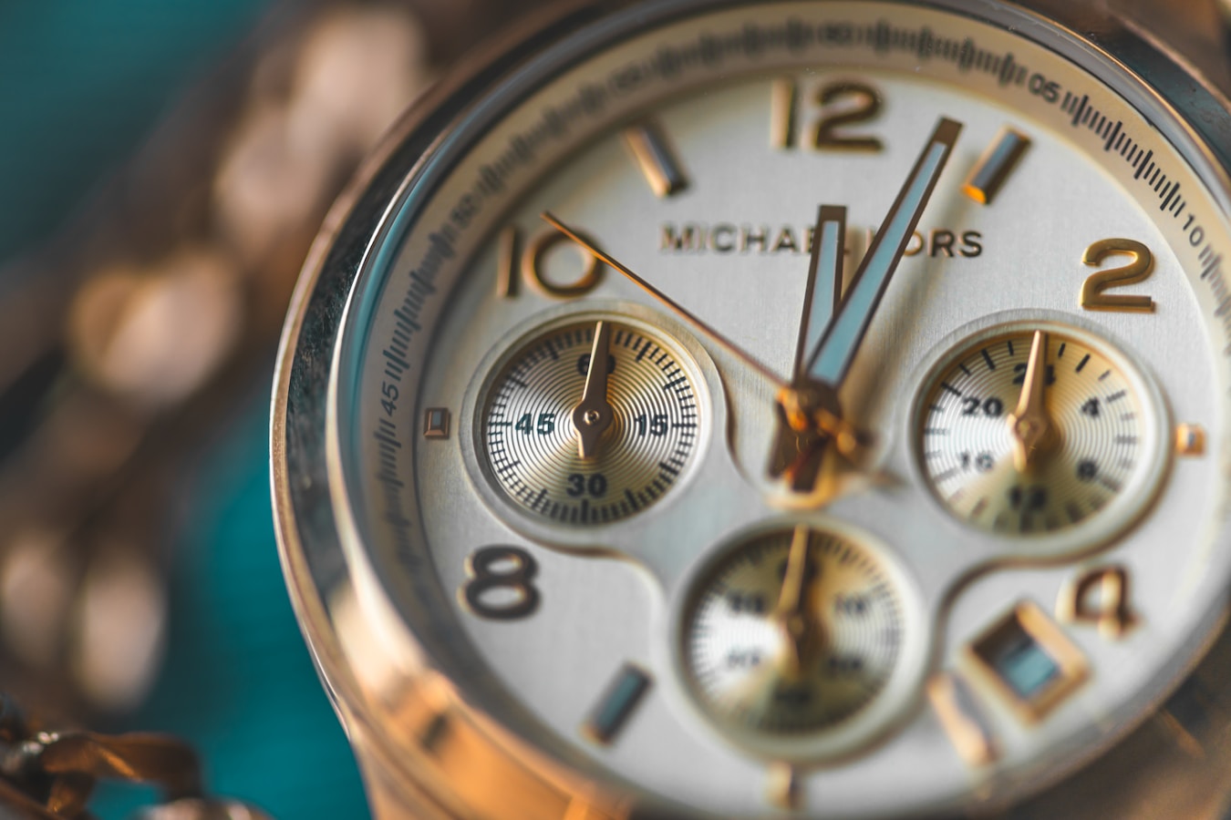 round gold-colored Michael Kors chronograph watch
