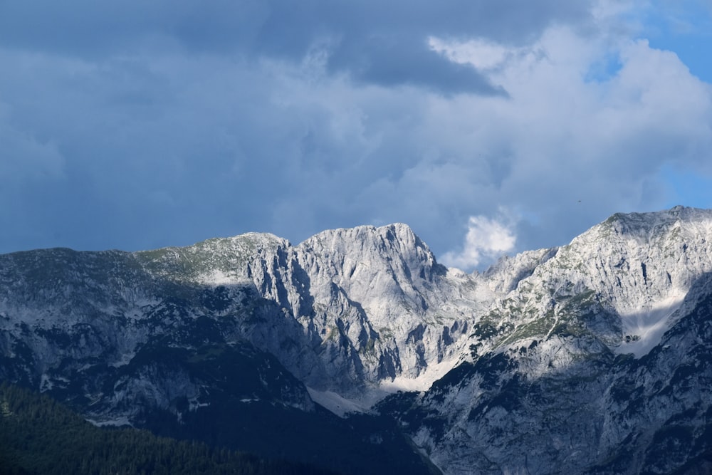 rock mountain under clouds