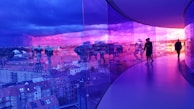 A panoramic view of a sky glass bridge with visitors walking over it.