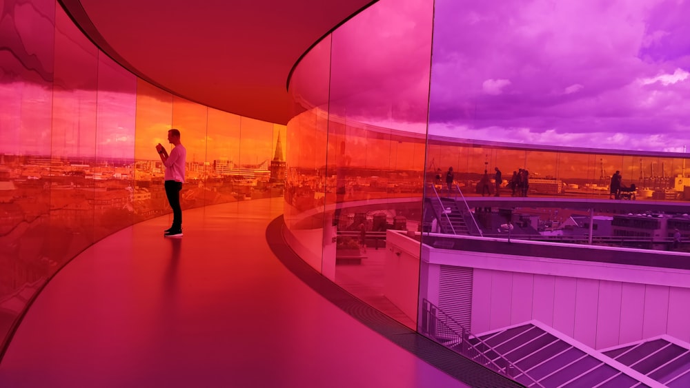 man standing on pathway in middle on glass wall