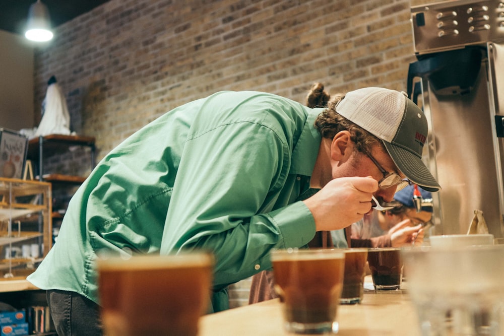 man tasting drink on cup